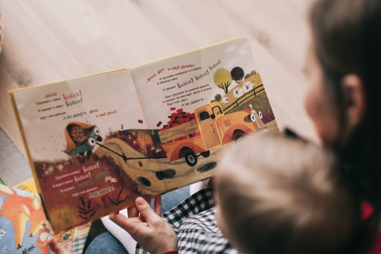 woman reading book to toddler